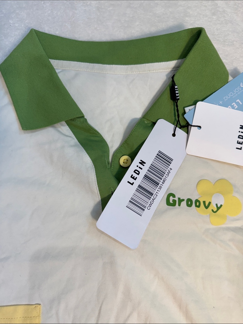 Ledin “Groovy” white crop top with green collar and sleeve accents. L.